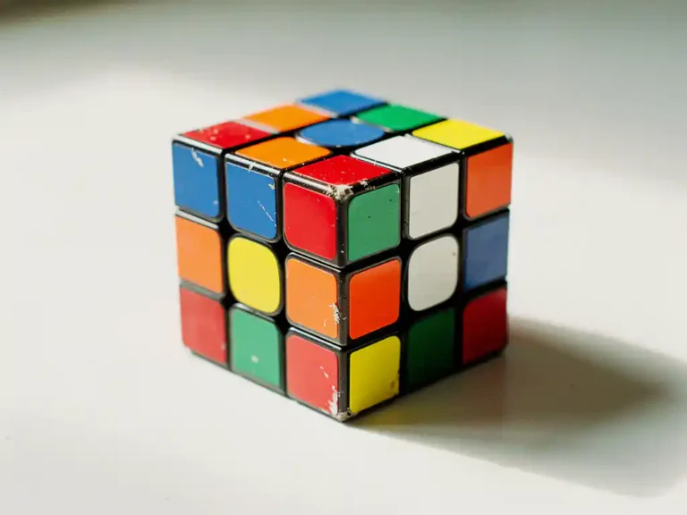 Klassieke 3x3 Rubik's kubus met gekleurde vierkanten op witte ondergrond in natuurlijk licht