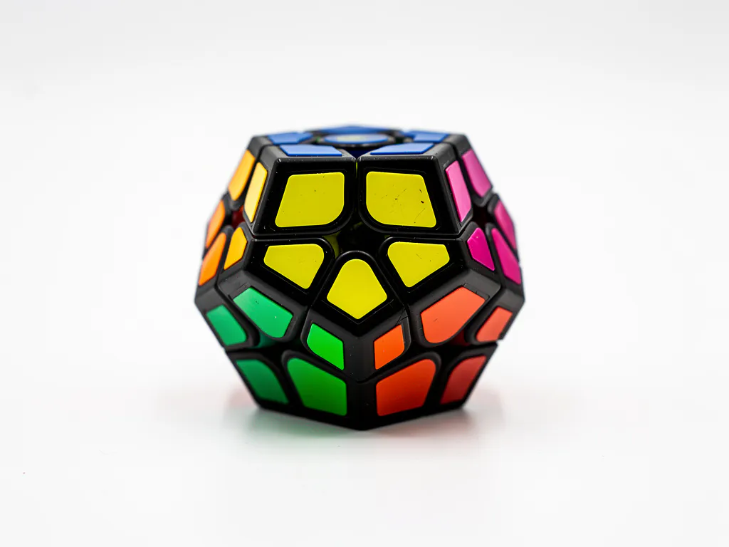 Megaminx dodecaëder puzzel met glanzende ABS-plastic vlakken in felle primaire kleuren op witte achtergrond.