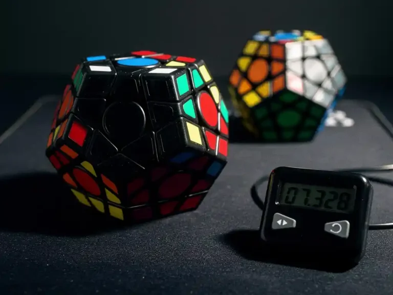Zwarte megaminx dodecaëder puzzel op competitiemat naast digitale kubus timer, dramatische zijverlichting met geometrische schaduwen.
